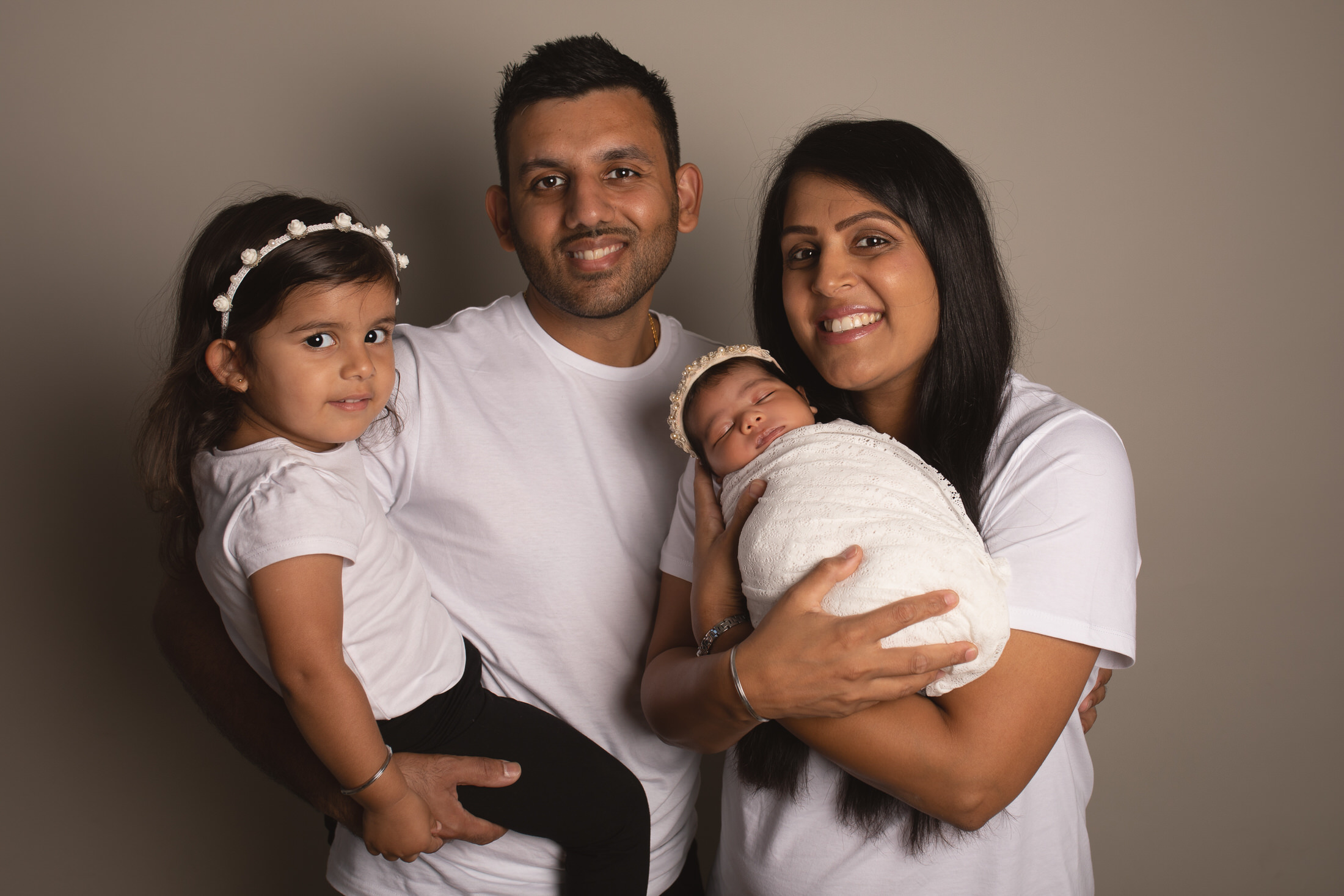 Family of four with baby and toddler, wearing white t-shirts by Newborn Photographer in Medway, Kent