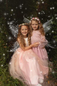 Fairy photoshoot - two girls wearing pretty pink dresses with fairy winds and added sparkle. Photographed in Medway, Kent.