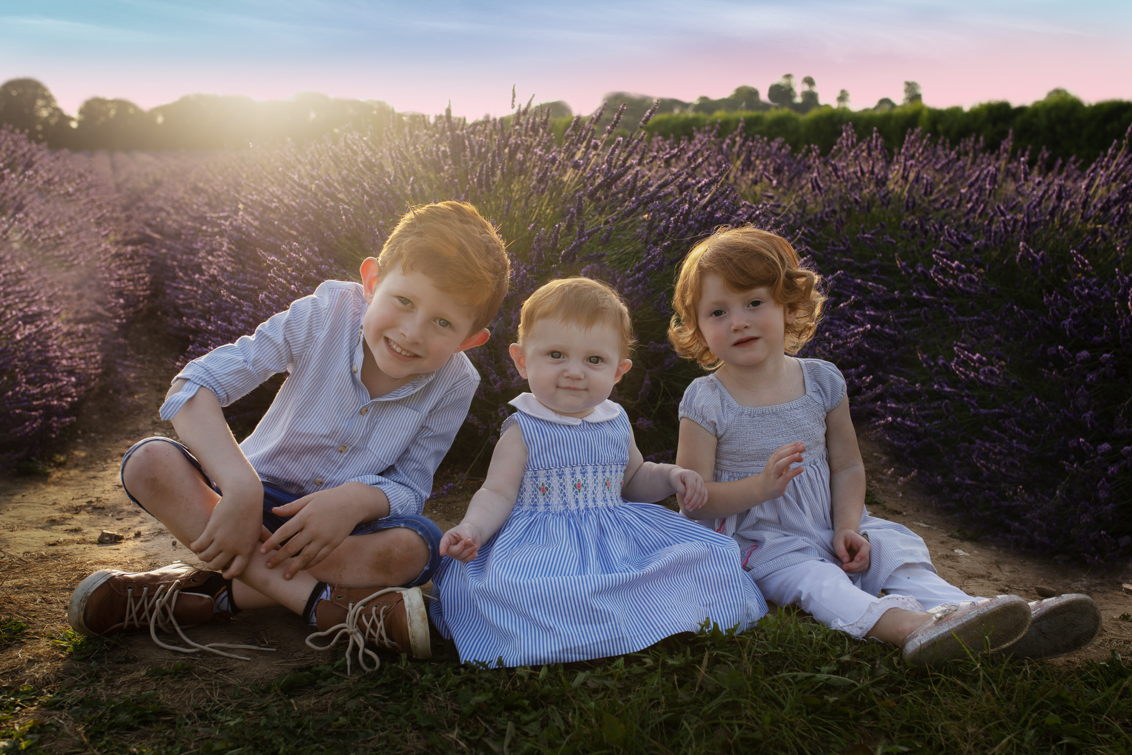family of three children in a lavender field at sunset by Newborn Photographer in Medway, Kent