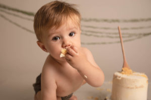 Cake Smash photo boy Medway Kent. 1 year old putting cake in his mouth.