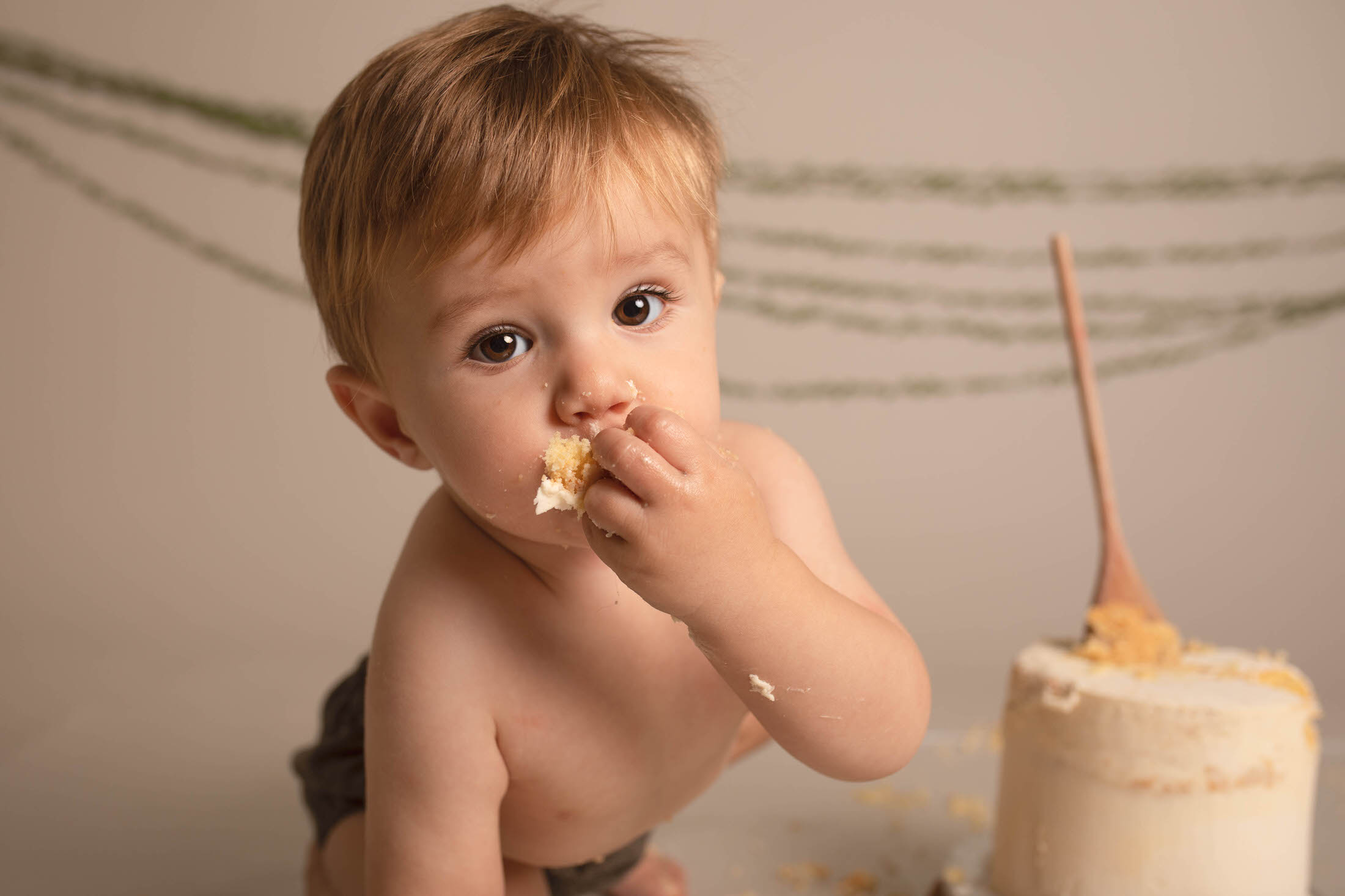 baby eating a sponge birthday cake by Newborn Photographer in Medway, Kent