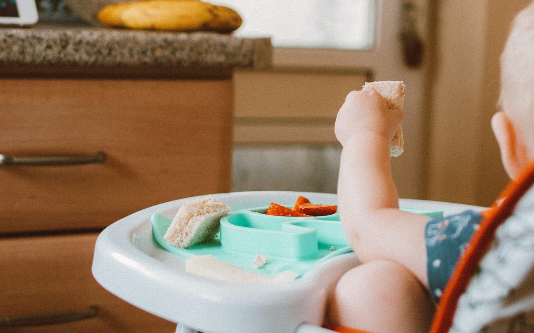 Baby weaning - a photo of a baby in a highchair with finger foods on tray. Kent Baby photographer Strood
