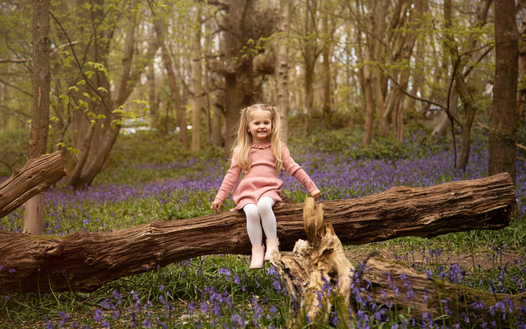 Girl in pink dress amoung bluebells in Trosley Park Kent. Family photographer