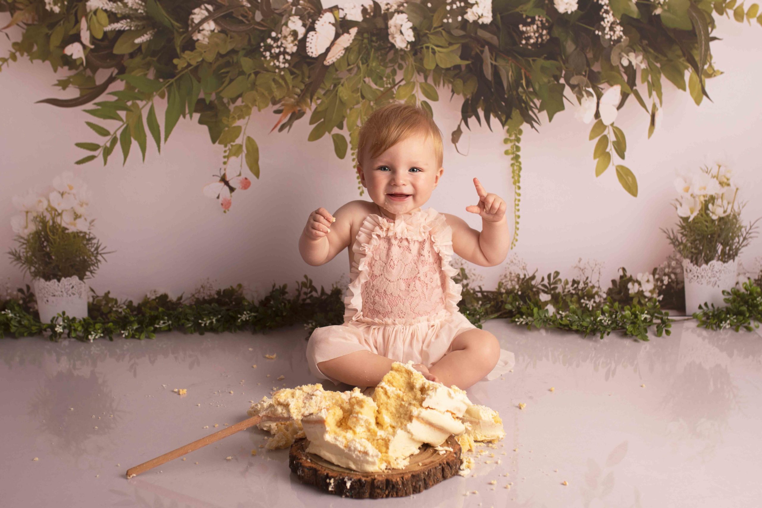Cake Smash Photoshoot - celebrate babies first birthday. This little girl is smashing the cake with big smile on her face. Photographed in my studio in Strood, Medway 