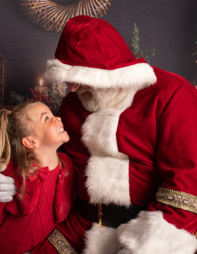 Photo of Father Christmas with a little girl both dressed in red. Photographed in Medway, Kent by Hannah Cornford Photography