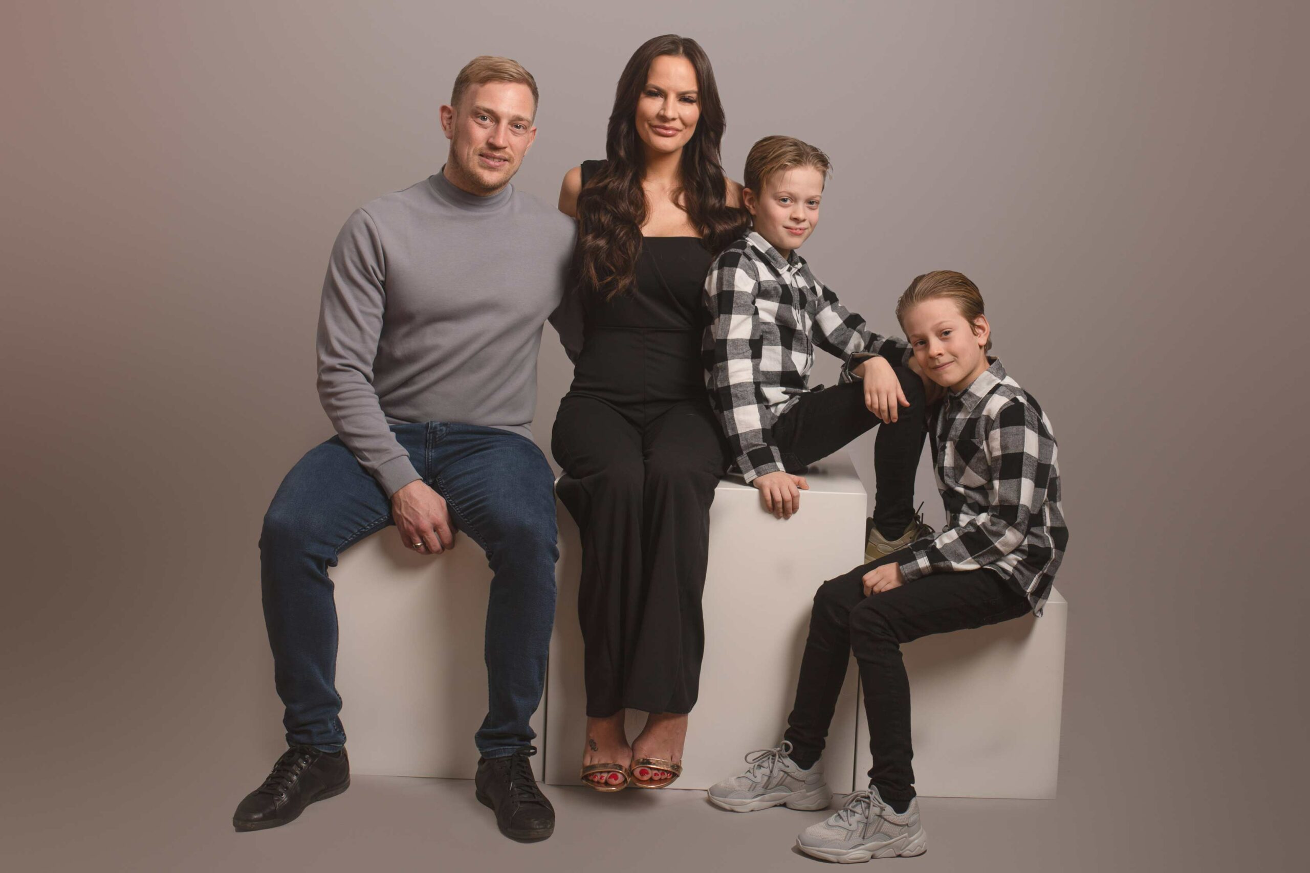 Family photos taken in the studio with cream backdrop. Family are co-ordinating in black and white. Photographed by Hannah Cornford Photography in Strood studio