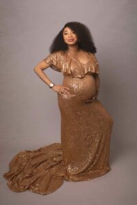 Pregnant lady wearing stunning gold maternity gown. Photographed by Hannah Cornford photography in medway studio on a cream backdrop.