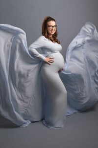 Maternity photoshoot - mum to be wearing baby blue fitted dress with floaty material. 